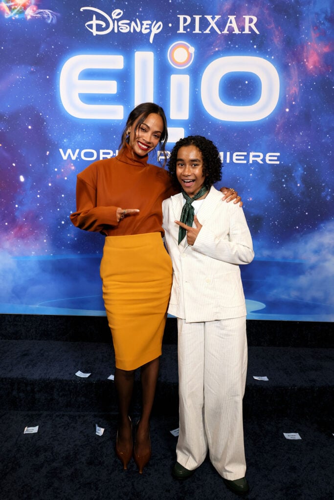 Zoe Saldaña and Yonas Kibreab attend the World Premiere of Disney and Pixar's "Elio" in Saint Laurent orange top and yellow skirt