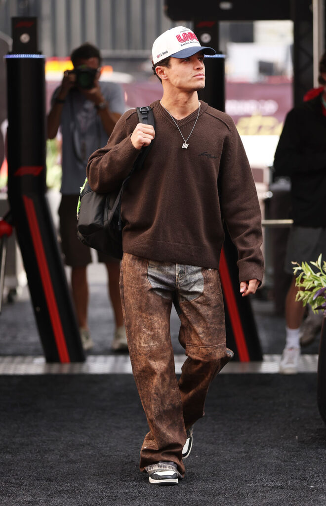 Lando Norris of Great Britain and McLaren arrives in the Paddock during previews ahead of the F1 Grand Prix of United States at Circuit of The Americas, Lando Norris, Acne Studios Fall 2025, F1 paddock, brown look, racing style, menswear streetwear, Formula 1 fashion