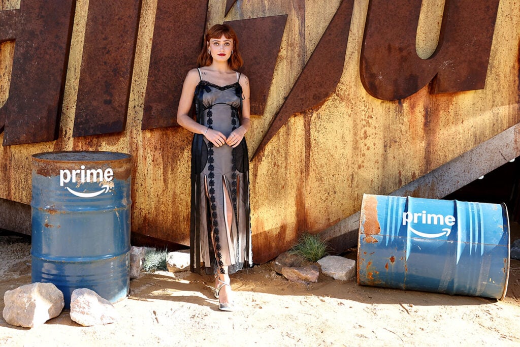 Ella Purnell Wore Simone Rocha To The 'Fallout Season 2' Sydney Screening, Ella Purnell, Fallout Season 2 Sydney screening red carpet, Simone Rocha Fall 2025, Simone Rocha ribbon daisy chain dress, Ella Purnell style, Amazon Prime Video Fallout, Duha Claudia metallic silver pumps, Cartier Love bracelet, Sydney red carpet