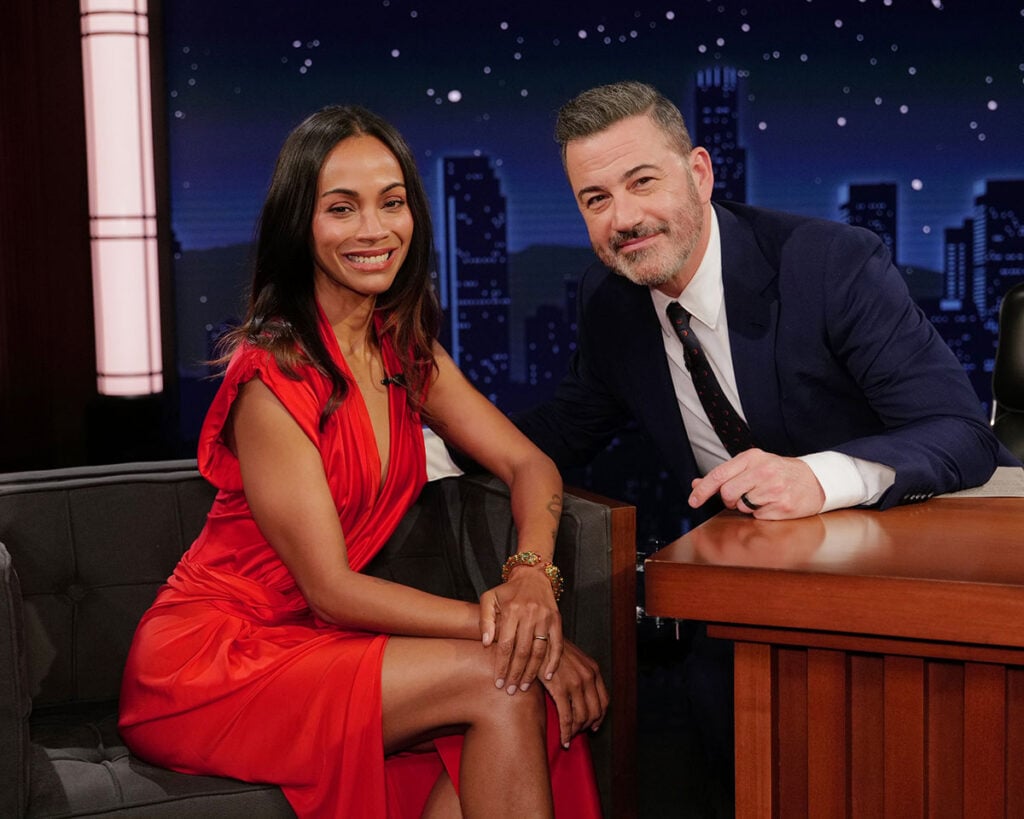 Zoe Saldana Jimmy Kimmel outfit, Zoe Saldana red dress TV appearance, Victoria Beckham red satin dress, asymmetric satin maxi dress celebrity, Zoe Saldana talk show fashion, late night TV fashion, Zoe Saldana red carpet style TV, celebrity red satin dress, Zoe Saldana Avatar interview look, Avatar: Fire and Ash