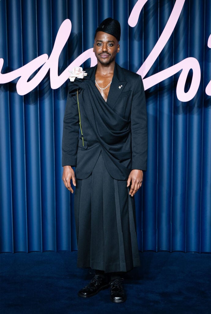 Ncuti Gatwa attends The Fashion Awards 2025 Ncuti Gatwa, Simone Rocha menswear, pleated menswear, draped menswear, Harvy Santos hat, rose detail menswear, statement tailoring, The Fashion Awards 2025 menswear, The Fashion Awards 2025 red carpet, London avant-garde menswear.