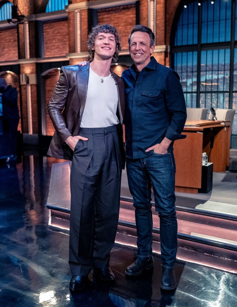 Connor Storrie, Late Night with Seth Meyers, Heated Rivalry actor, Connor Storrie red carpet style, Tom Ford menswear, late night TV appearance fashion, IWC Portofino Complete Calendar