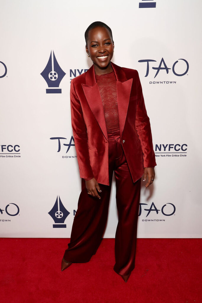 Lupita Nyong’o, Lupita Nyong’o red carpet, Lupita Nyong’o Alice + Olivia, Alice + Olivia suit red carpet, New York Film Critics Circle Awards red carpet, NYFCC Awards fashion, maroon suit red carpet, lace bodysuit red carpet, Lupita Nyong’o awards season style