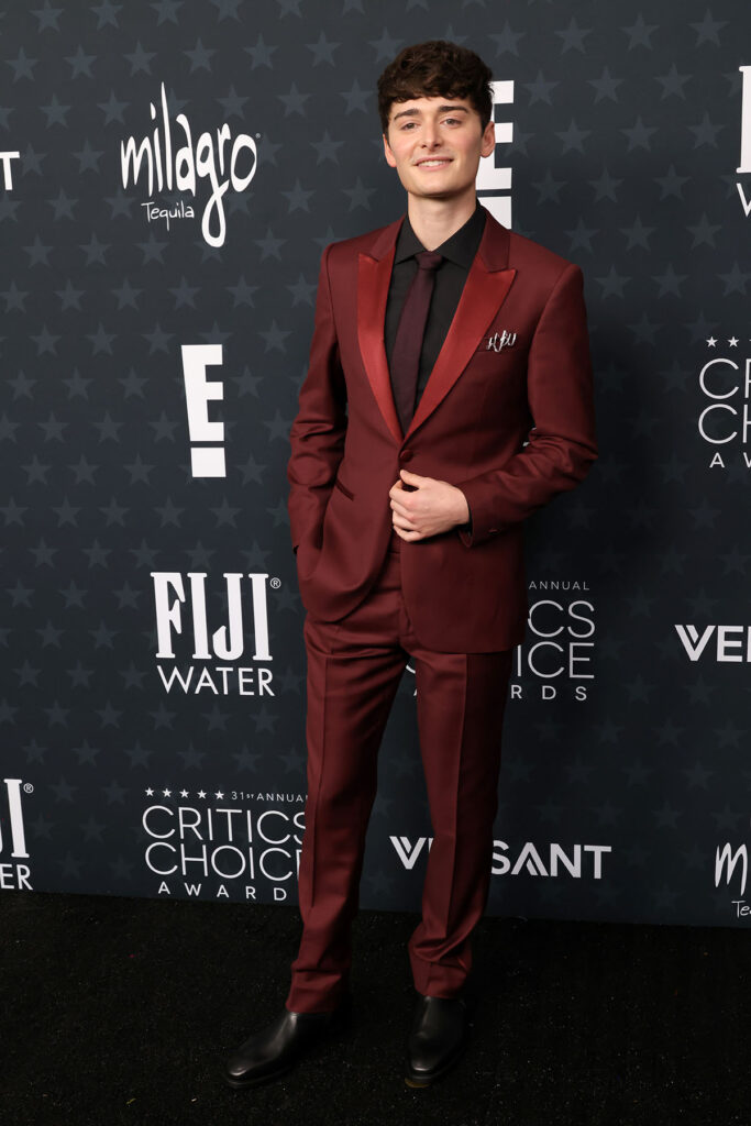 Noah Schnapp, 2026 Critics’ Choice Awards menswear, John Varvatos tuxedo, black shirt tuxedo, Gen Z menswear, red carpet styling choices