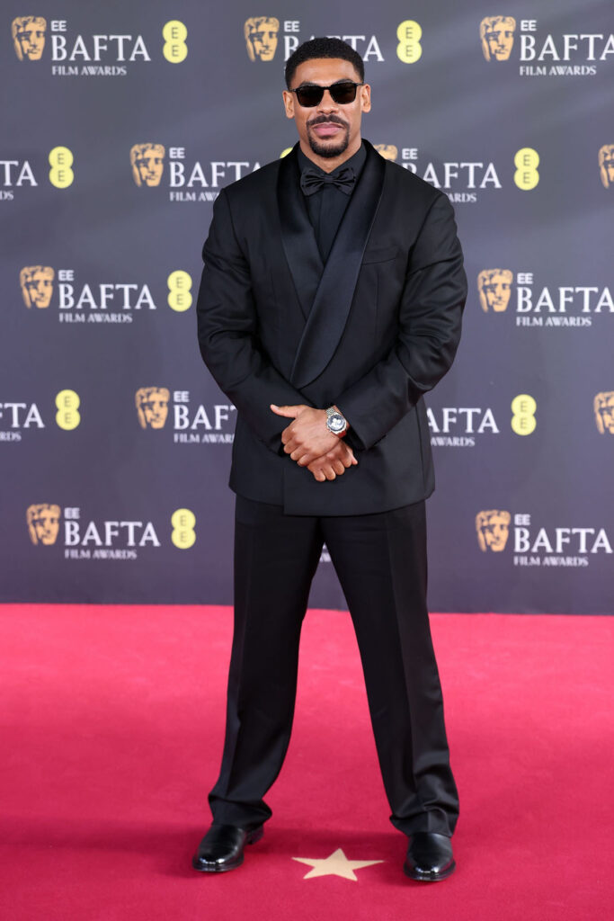 Aaron Pierre, Aaron Pierre BAFTAs 2026, BAFTAs menswear, BOSS custom tuxedo, black bow tie look, OMEGA Speedmaster Moonwatch Professional, black tie red carpet