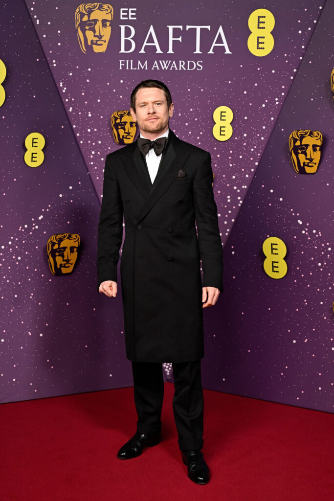 Jack O’Connell, Jack O’Connell BAFTAs 2026, BAFTAs menswear, dunhill overcoat, long black coat tailoring, OMEGA timepiece