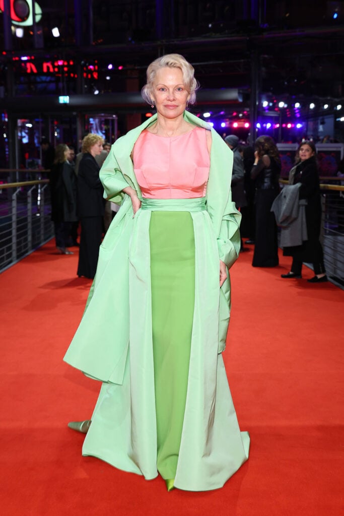 Pamela Anderson Berlin Film Festival 2026, Pamela Anderson Rosebush Pruning premiere, Carolina Herrera Fall 2025 mini cape, Carolina Herrera Resort 2026 gown, Berlin Film Festival red carpet 2026, Pamela Anderson photocall look, Pamela Anderson premiere gown, Carolina Herrera brocade cape, Carolina Herrera Resort 2026 column gown