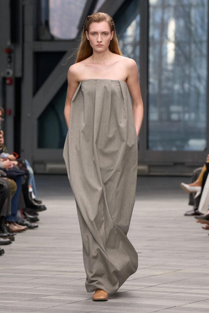 Calvin Klein Collection Fall 2026 grey wool pleated strapless column dress on the runway.