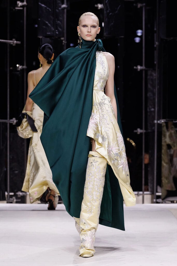 Givenchy Fall 2026 runway look by Sarah Burton with embroidered cape and floral boots