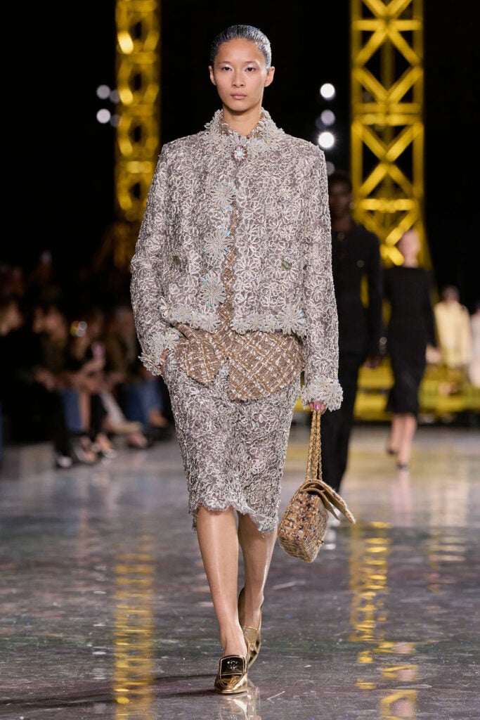 Chanel Fall 2026 silver lace look presented on the runway with metallic mixed-metal pumps.