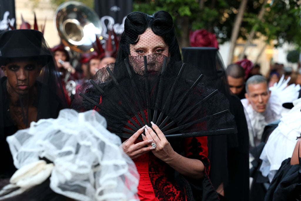 Lady Gaga holding a black lace fan while wearing archival Givenchy Haute Couture at Apple Music Live MAYHEM Requiem
