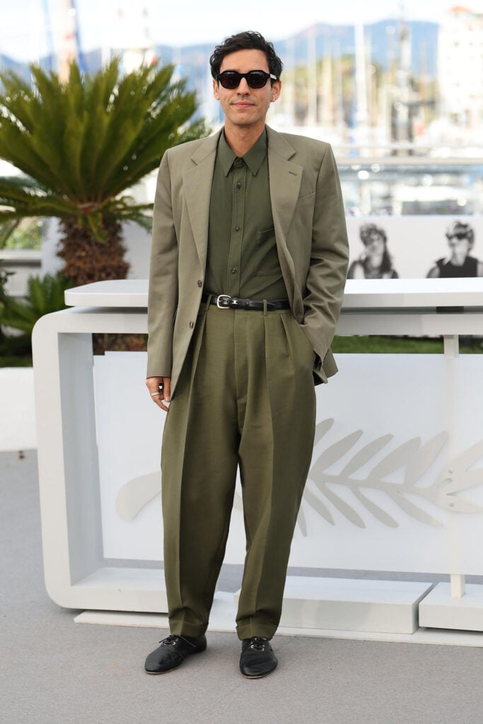 Adam Bessa wore an olive Celine suit and sunglasses to the Histoires Parallèles photocall at Cannes Film Festival.