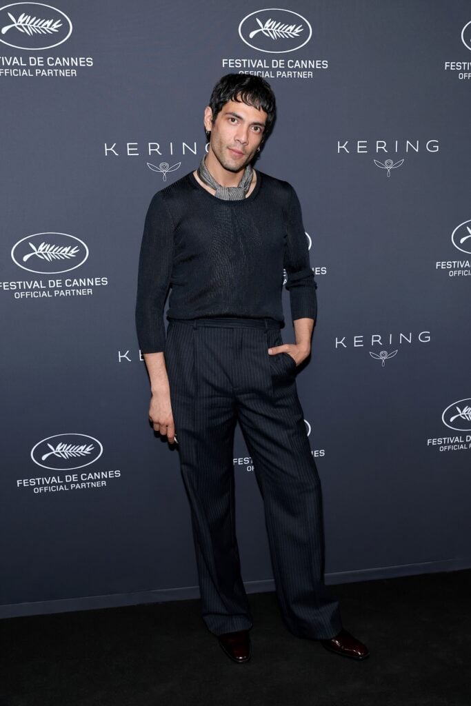 Diego Calva wore Saint Laurent pinstripe trousers and a sheer knit top to Kering’s Women In Motion dinner in Cannes.