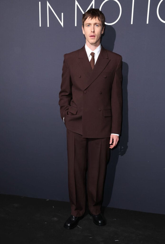 Harris Dickinson wore a custom brown Balenciaga suit to the Kering Women In Motion dinner during Cannes Film Festival.