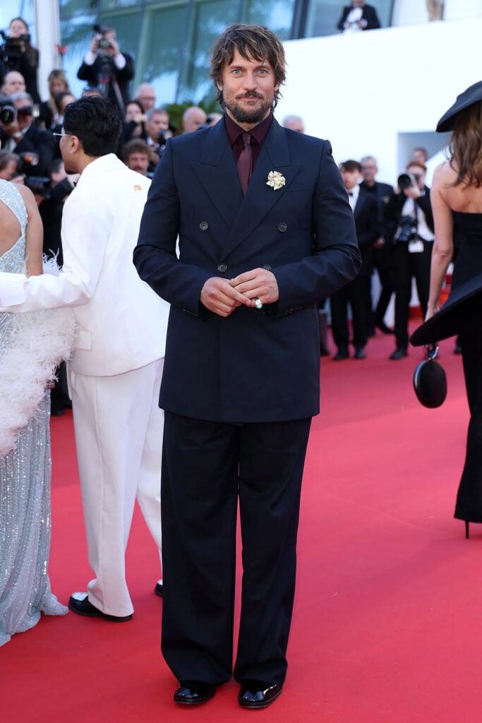 Lucas Bravo wore a navy Saint Laurent double-breasted suit to The Electric Venus premiere at Cannes Film Festival.