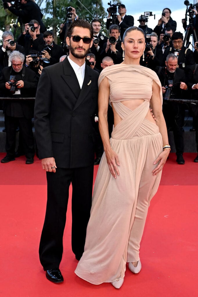 Pierre Niney wore a black Balenciaga suit with Boucheron jewelry alongside Natasha Andrews at Cannes Film Festival.