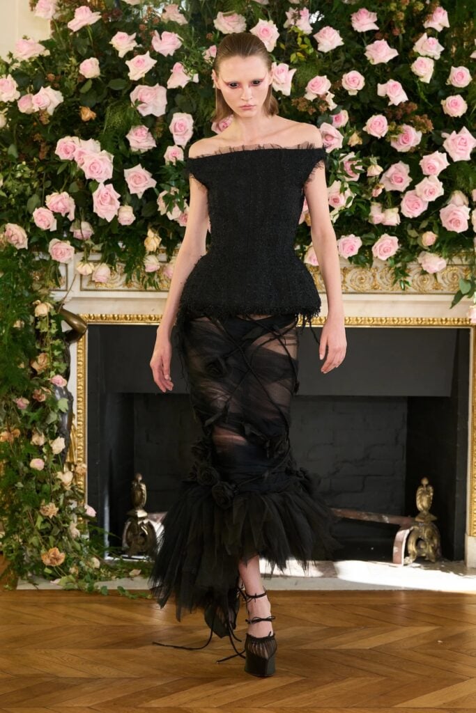 Matières Fécales runway look with flared trousers and layered black styling.