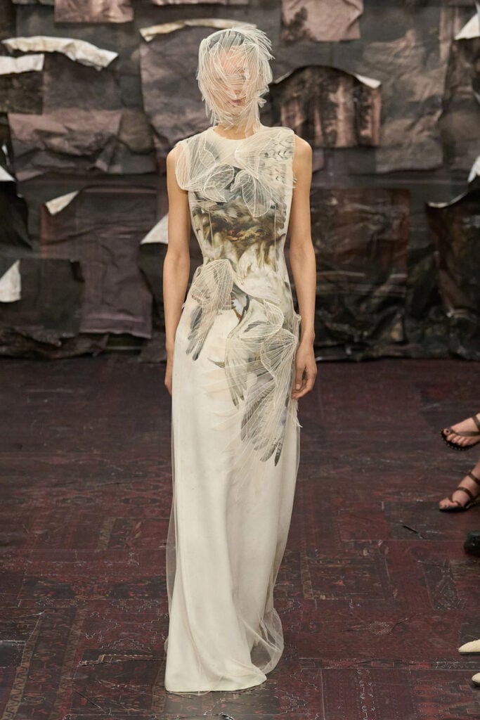 Model presents the Maison Margiela Artisanal design featuring painted imagery and sculptural tulle elements.