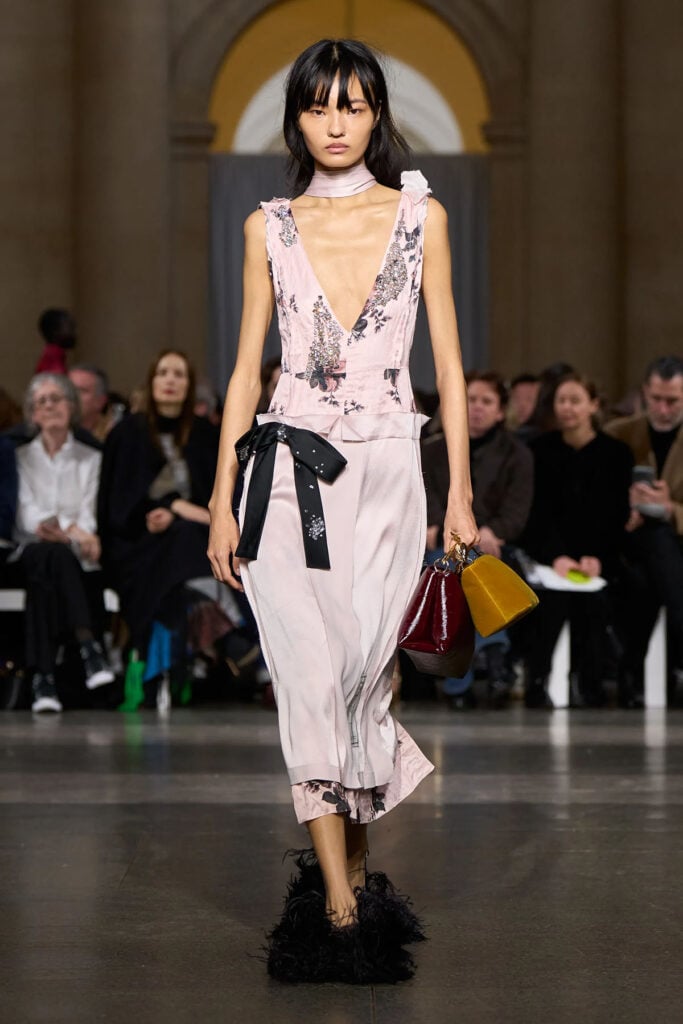 Model walks the Erdem Fall 2026 runway wearing the embellished pink dress with layered skirt detail
