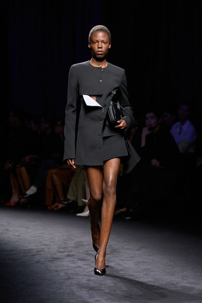 Ferragamo Fall 2026 black wool jacket and skirt with contrasting mascarpone panels on the runway.