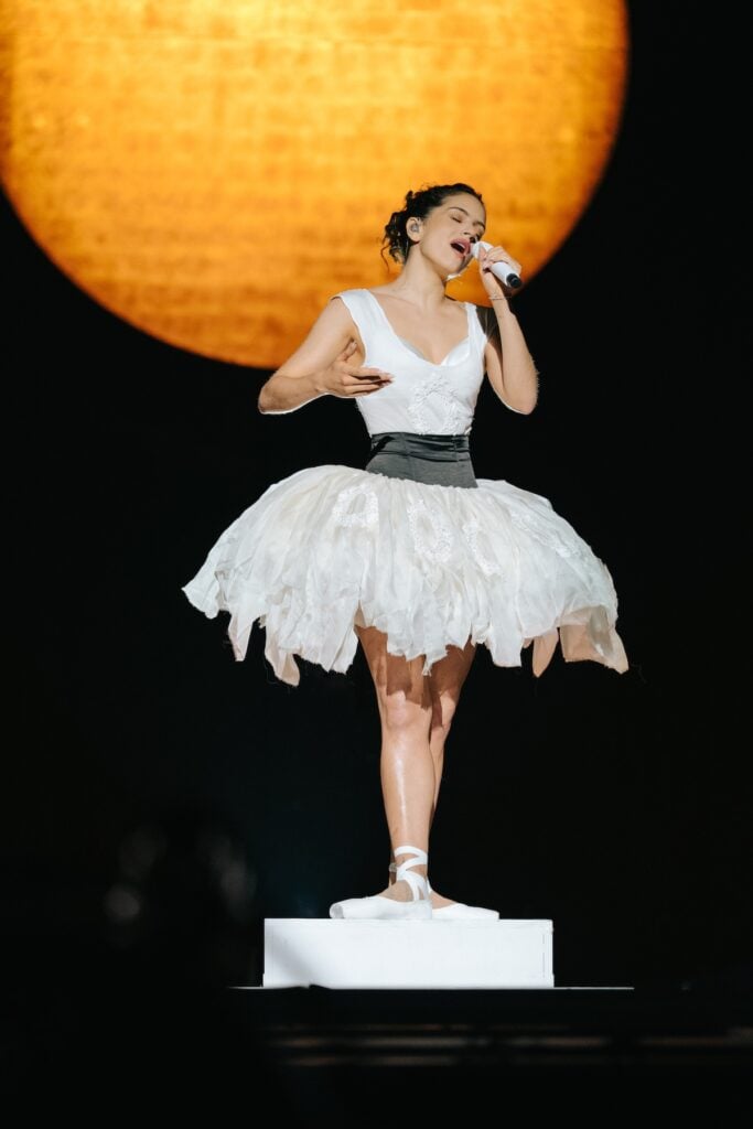 Rosalía performing on the LUX World Tour wearing a custom Dior ivory ballet-inspired tutu look designed by Jonathan Anderson