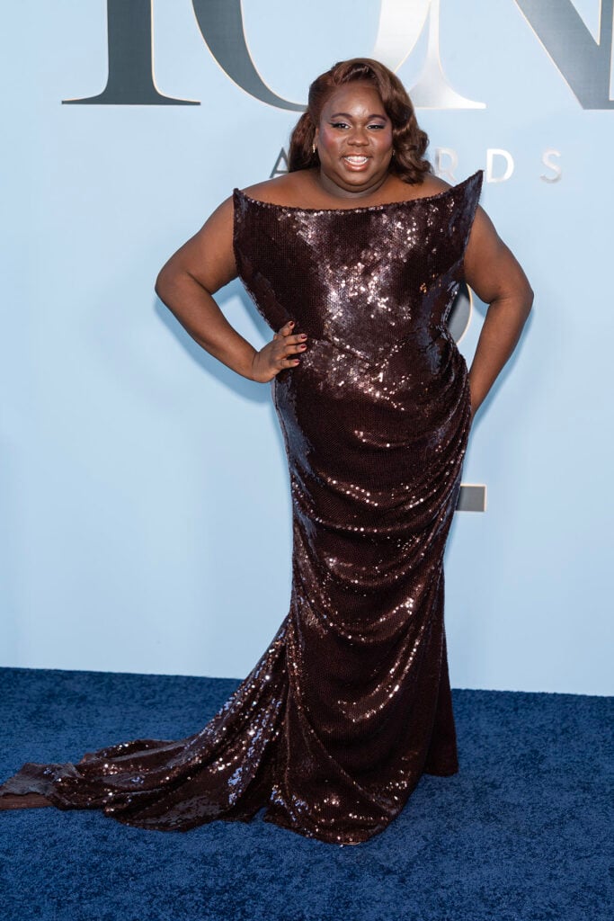 Alex Newell wears a custom Christian Siriano chocolate sequin gown at the 2026 Tony Awards.