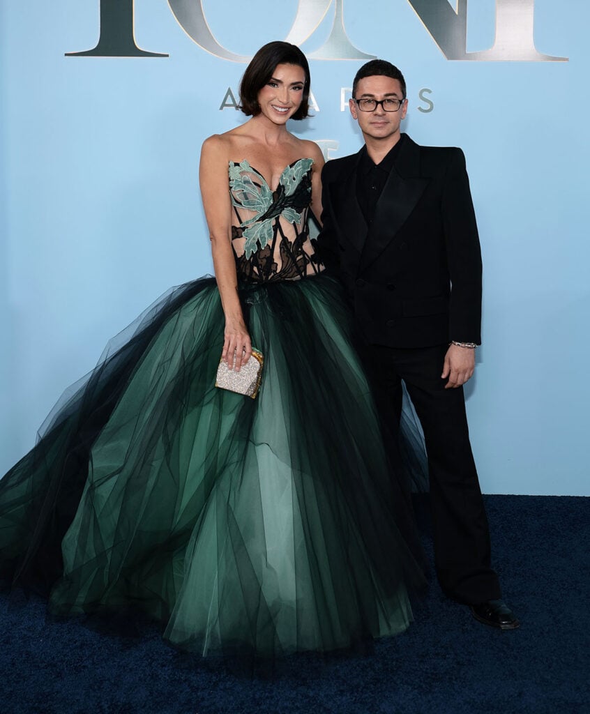 Bronwyn Newport wears a Christian Siriano black-and-seafoam corseted tulle ballgown alongside the designer at the 2026 Tony Awards.