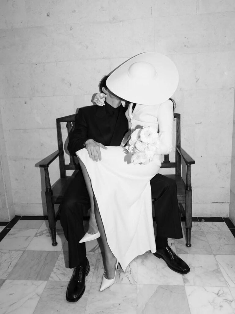 Dua Lipa in Schiaparelli Haute Couture carrying flowers during her London civil wedding ceremony.