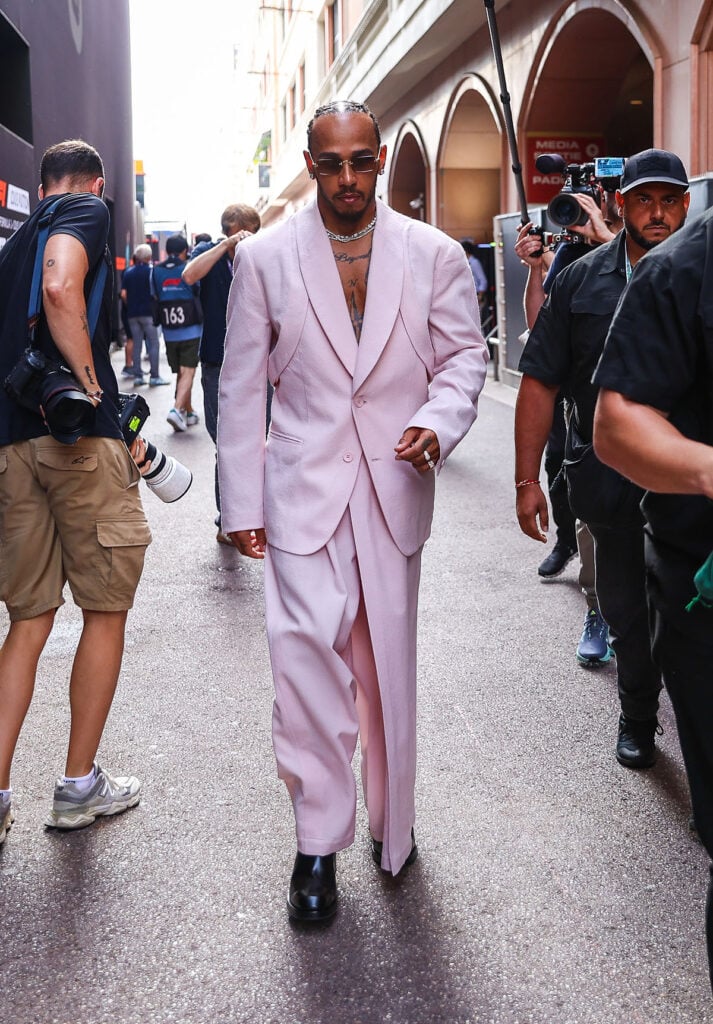 Lewis Hamilton wearing an Issey Miyake Fall 2026 pink tailored look at the Monaco Grand Prix paddock