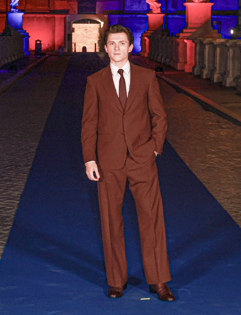Tom Holland wears a custom Louis Vuitton burgundy suit at the Spider-Man: Brand New Day premiere in Rome.