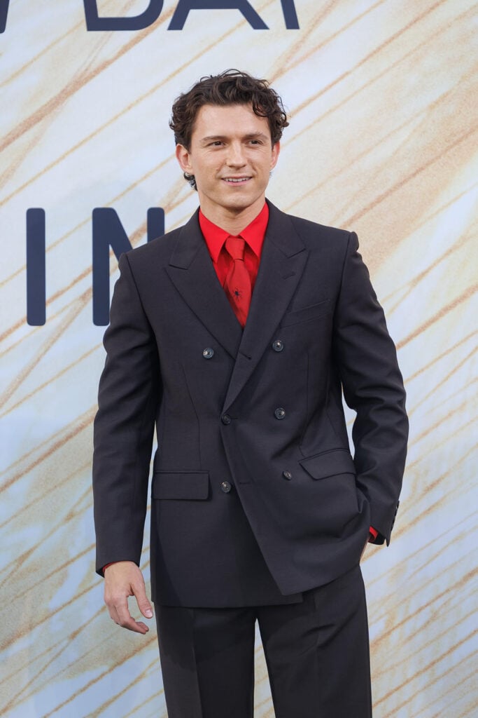 Tom Holland wears a custom Celine suit with Spider tie.