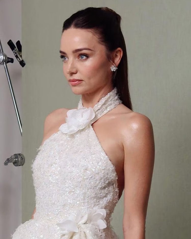 Miranda Kerr at the 2026 Met Gala wearing a white gown with glossy half-up hair styled using Glaze products