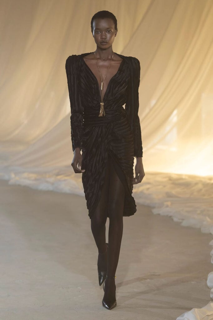 Model walks the Balmain Fall 2026 runway wearing the black crushed velvet dress later worn by Zoe Saldaña.