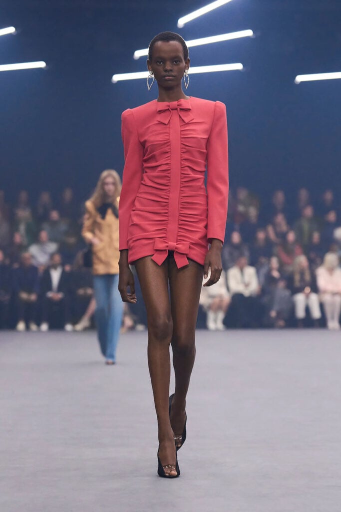 Valentino Spring 2026 coral ruched mini dress with oversized bows on the runway.