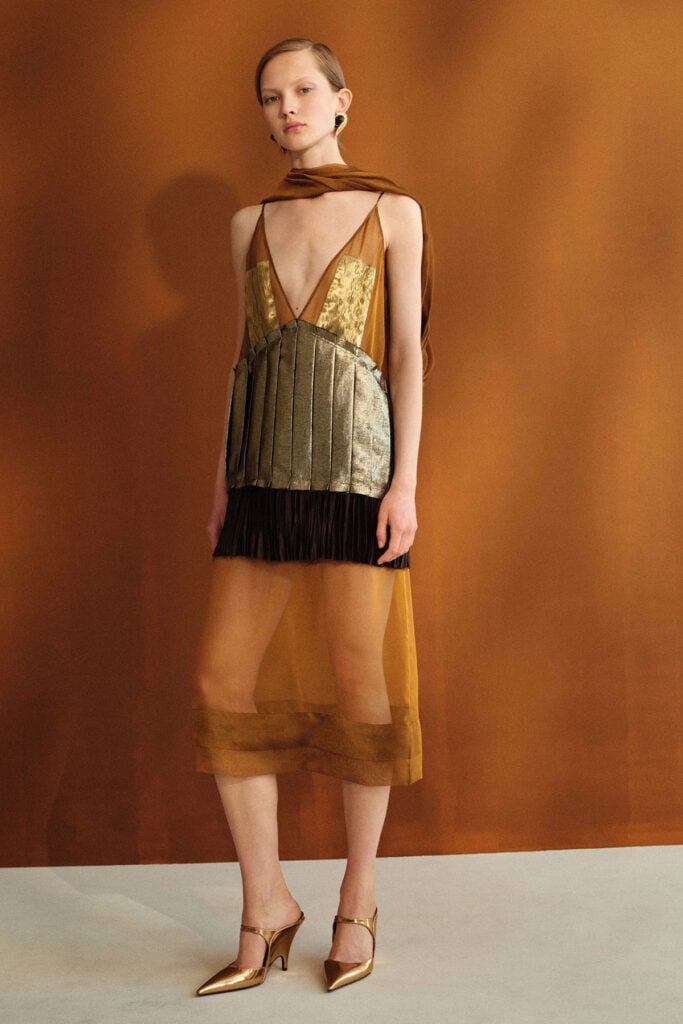 Ferragamo Resort 2027 runway look with metallic panels and layered scarf detail.
