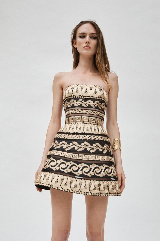 Carolina Herrera Resort 2026 black strapless mini dress with ornate gold embroidery from the collection look book.