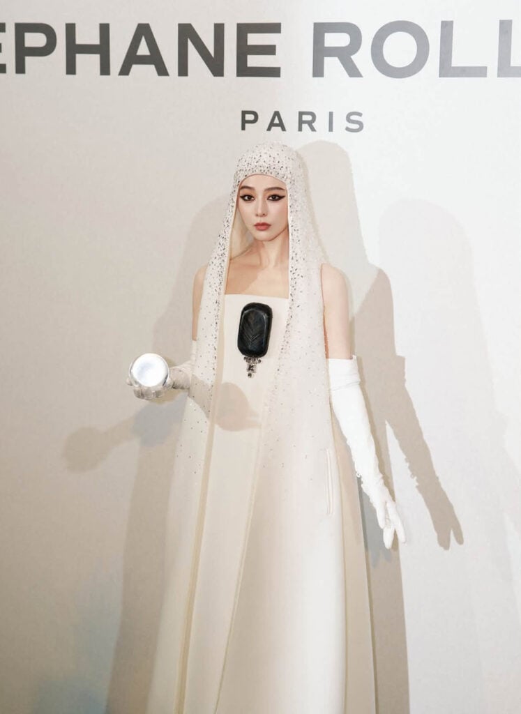 Close-up of Fan Bingbing in Stéphane Rolland Fall 2026 Couture with crystal hood and orb accessory.