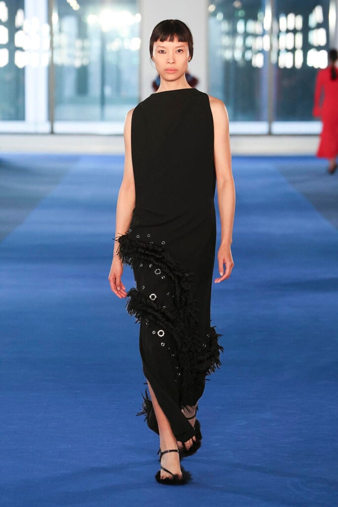 Proenza Schouler Fall 2026 black dress with an asymmetric embellished fringe skirt panel on the runway.