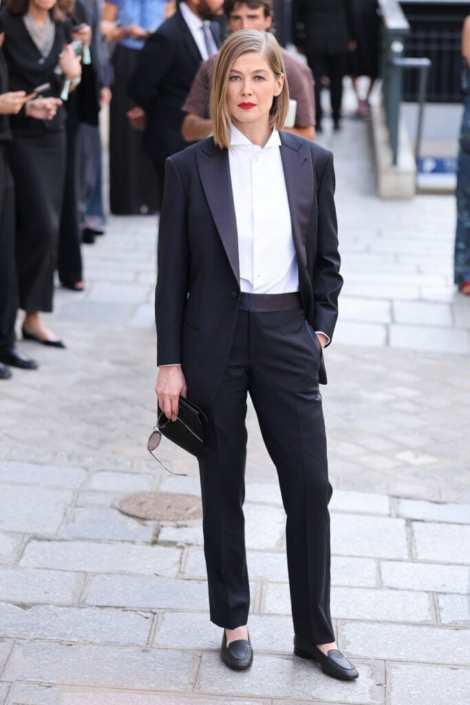 Rosamund Pike wears a black Armani tuxedo to the Armani Privé Fall 2026 show during Paris Fashion Week.