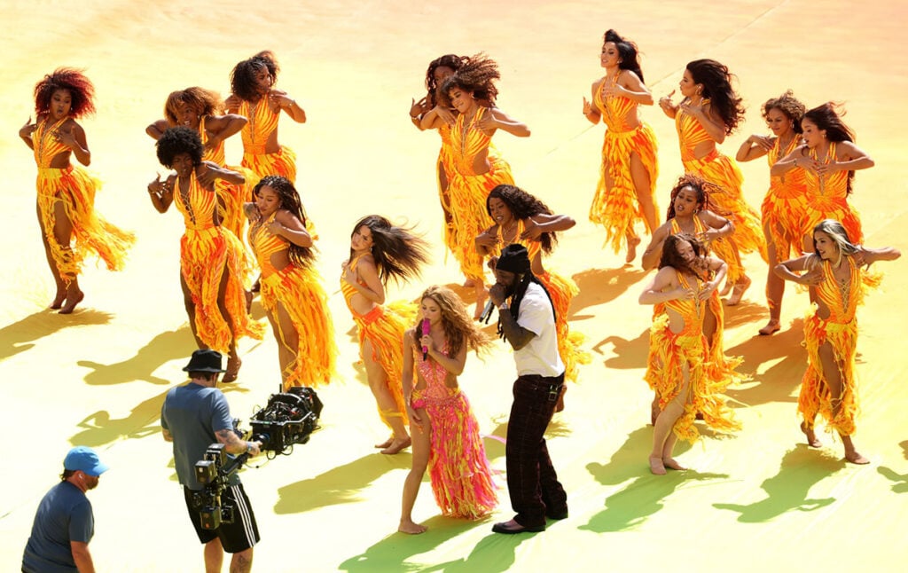 Shakira performs with dancers in a custom Roberto Cavalli Ray of Sunset look during the FIFA World Cup Final halftime show.