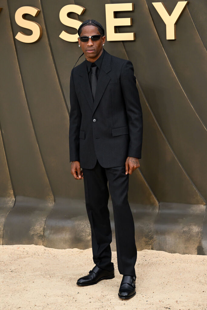 Travis Scott wearing a black pinstripe suit at The Odyssey world premiere in London.