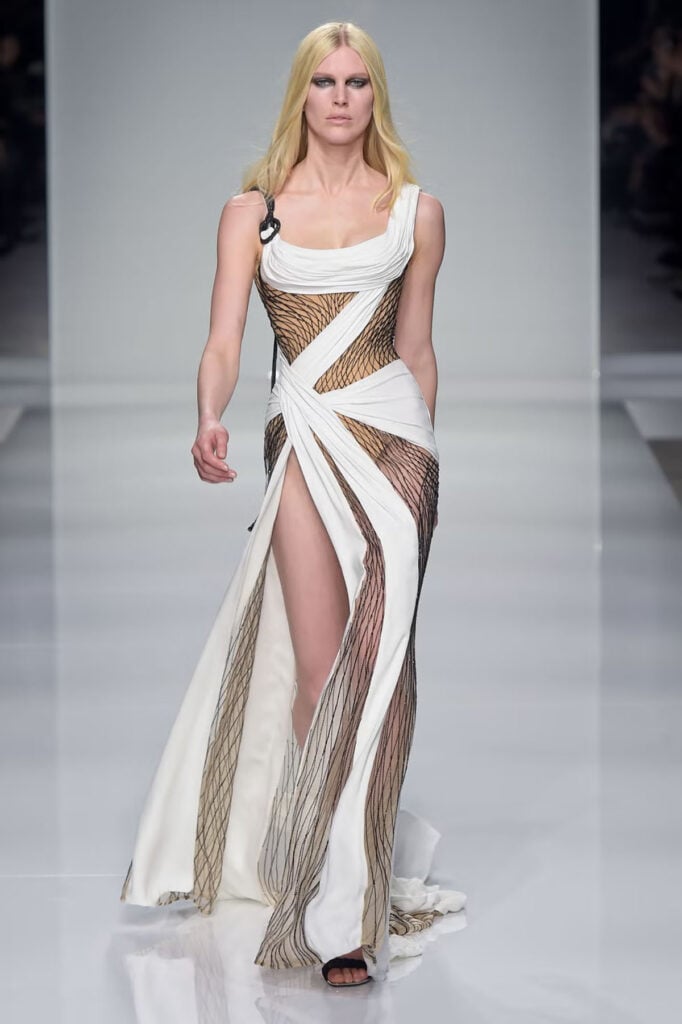 Atelier Versace Spring/Summer 2016 Couture runway gown featuring a sheer black lattice design with sweeping ivory draping.