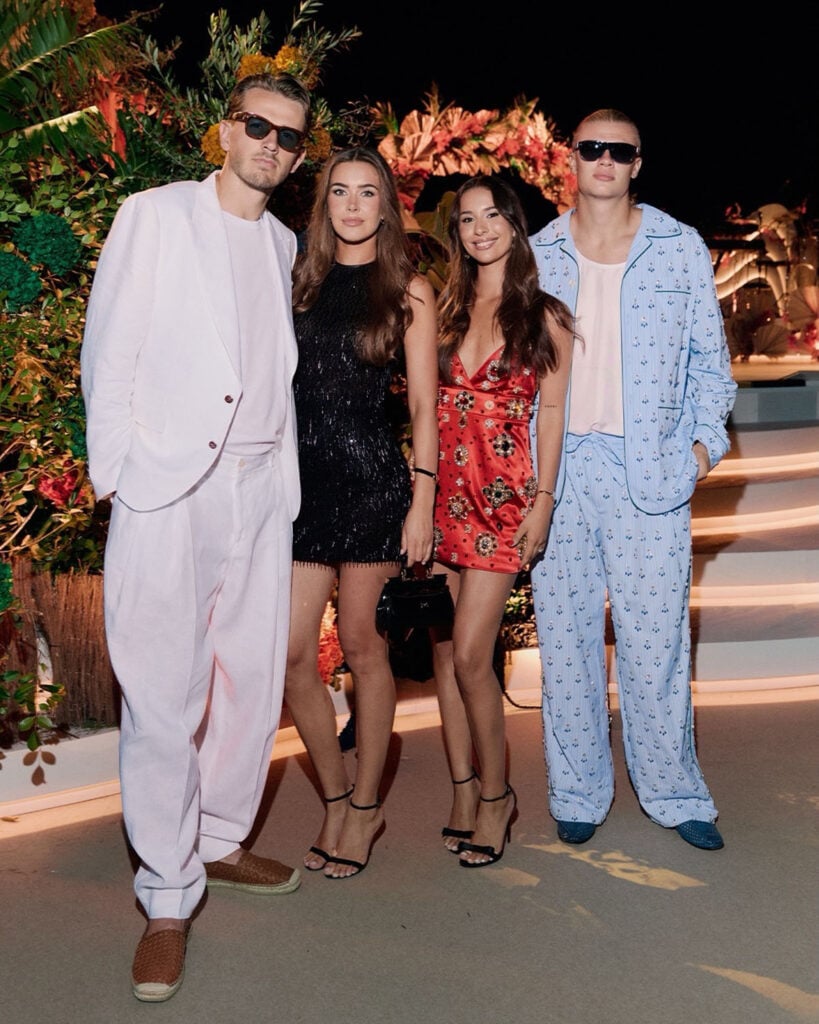 Erling Haaland with girlfriend Isabel Haugseng Johansen and friends wearing a blue embroidered Dolce & Gabbana pyjama-inspired look during his summer holiday.