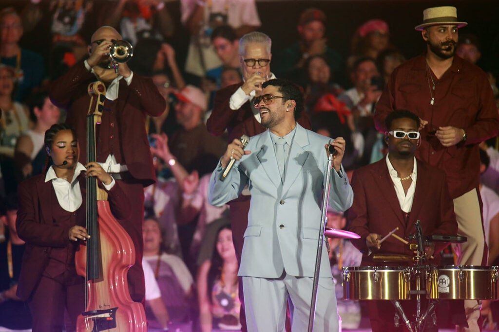 Bad Bunny performing with his band in a pale-blue Saint Laurent suit during his DeBÍ TiRAR MáS FOToS World Tour finale in San Juan, Puerto Rico.