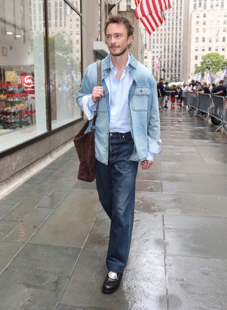 Drew Starkey wears Dior double denim with a brown suede Diorly bag while promoting 'Outer Banks' in New York.