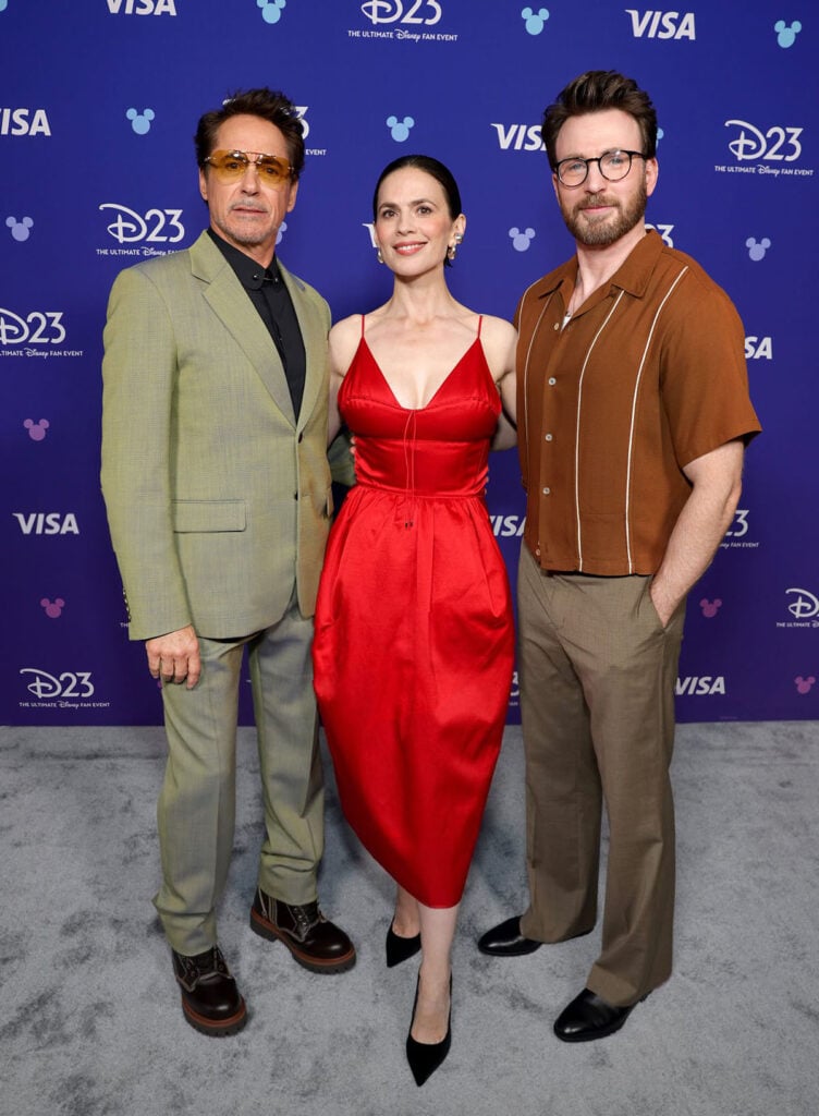 Robert Downey Jr., Hayley Atwell and Chris Evans attend the D23 Expo 2026 for 'Avengers: Doomsday'. Hayley Atwell wears a red Hermès Resort 2027 dress at the D23 Expo 2026 for 'Avengers: Doomsday'.