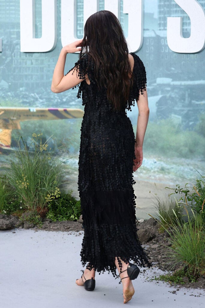 Margaret Qualley shows the back of her black Chanel Resort 2027 paillette dress and soleless sandals at ‘The Dog Stars’ London premiere.