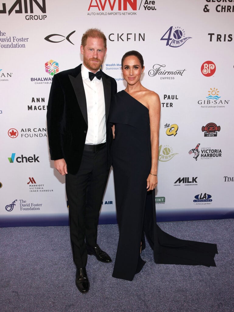 Meghan Markle in a black Greta Constantine one-shoulder gown with Prince Harry at the David Foster Foundation celebration in Victoria.