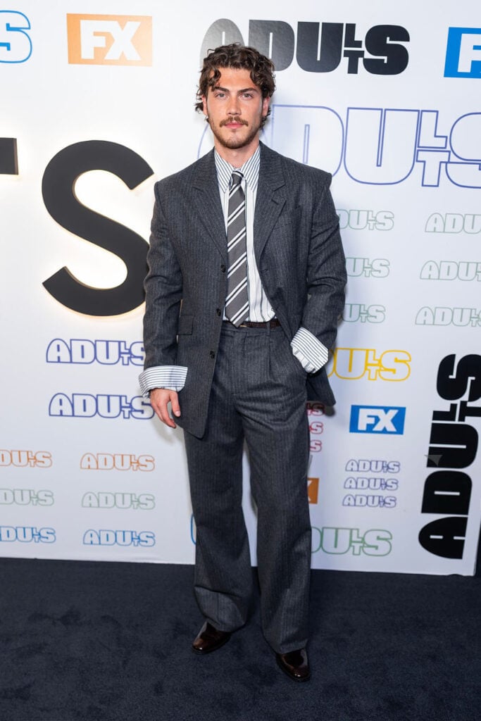 Jack Innanen wears a grey Saint Laurent suit with a striped shirt and tie to the Adults Season 2 premiere in New York.