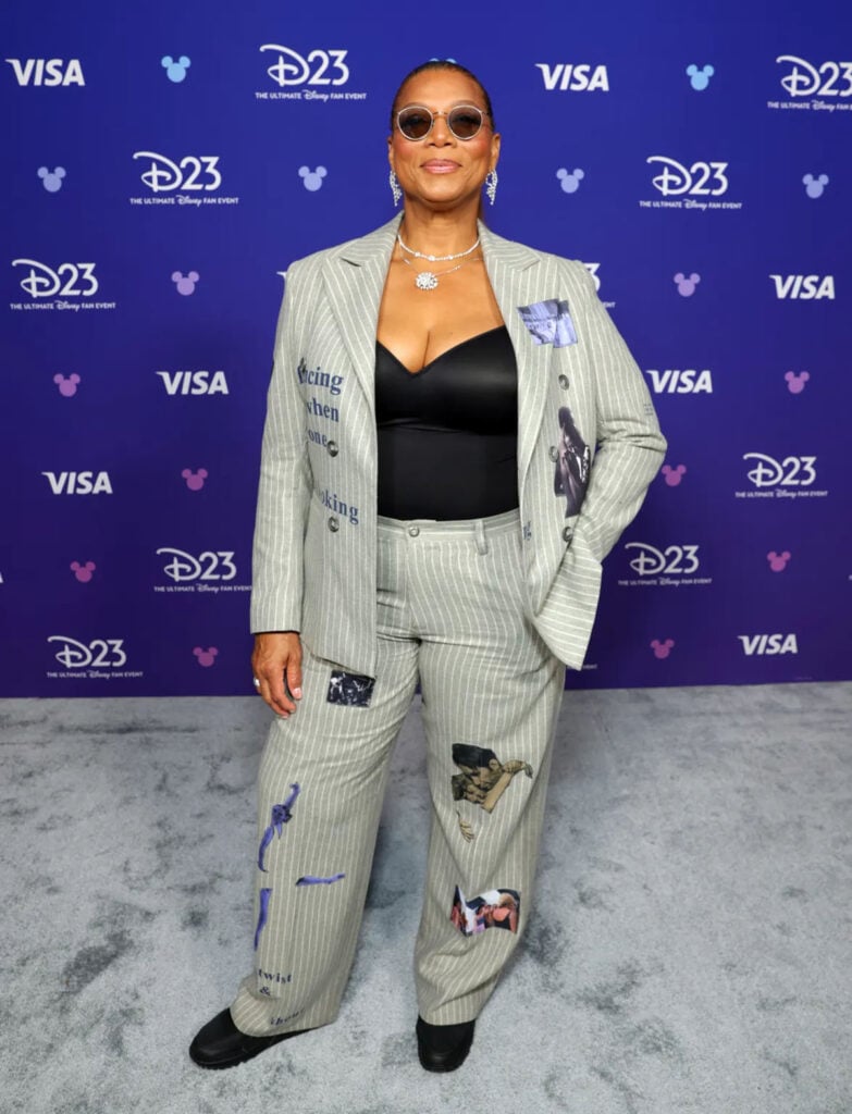 Queen Latifah wears a KidSuper pinstriped suit at the D23 Expo 2026 in Anaheim for 'Ice Age: Boiling Point'.
